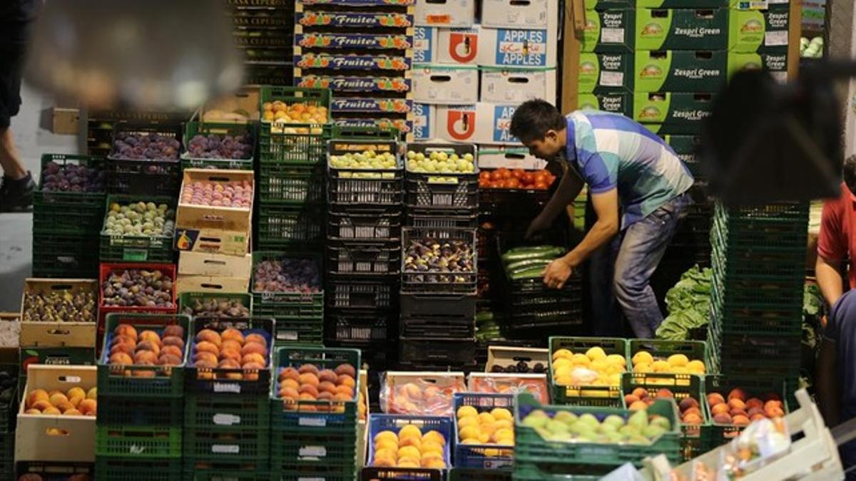 Un vendedor traslada cajas en el mercado central de frutas y verduras del Mercabarna.