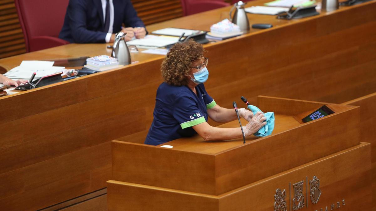 Personal de limpieza, desinfectando la tribuna durante la pandemia