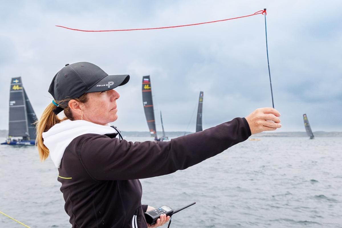 Maria Torrijo, juez, árbitro y oficial de regatas internacionales, comprobando la dirección del viento en el inicio de una competición.