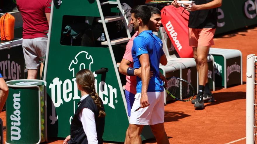 Carlos Alcaraz saluda a Novak Djokovic, con quien coincidió en el entrenamiento de ayer. | ROLAND GARROS