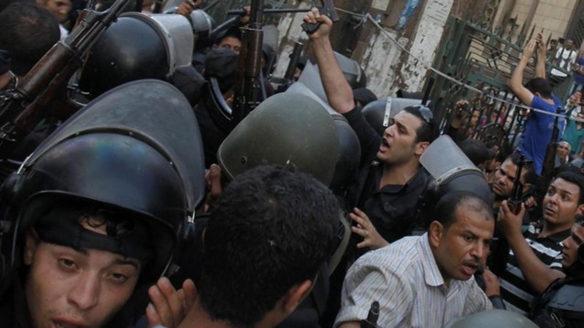 Un policía de paisano exhibe su pistola durante el desalojo de la mezquita de El Cairo donde se atrincheraron los islamistas, este sábado.