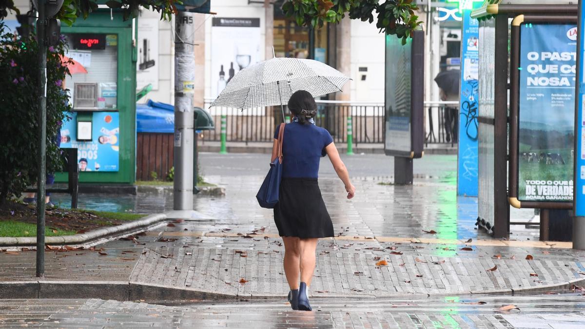Una mujer se protege de la lluvia con un paraguas en A Coruña.