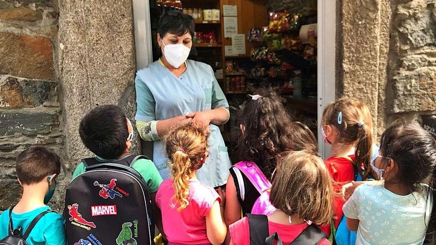 Niños y niñas del “Campamento Verde” con la dueña de un negocio lalinense.