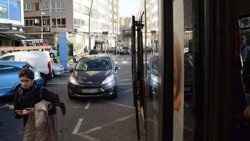 Un turismo detenido en doble fila en una zona señalizada para el uso del bus urbano.