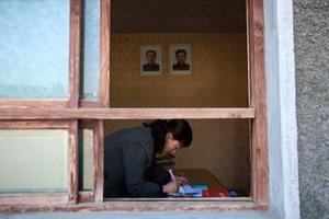 Una dona treballa a l’oficina d’un restaurant on estan penjats els retrats dels últims líders nord-coreans, Kim Il-Sung i Kim Jong-il, mort aquesta setmana, a Kaesong (Corea del Nord).