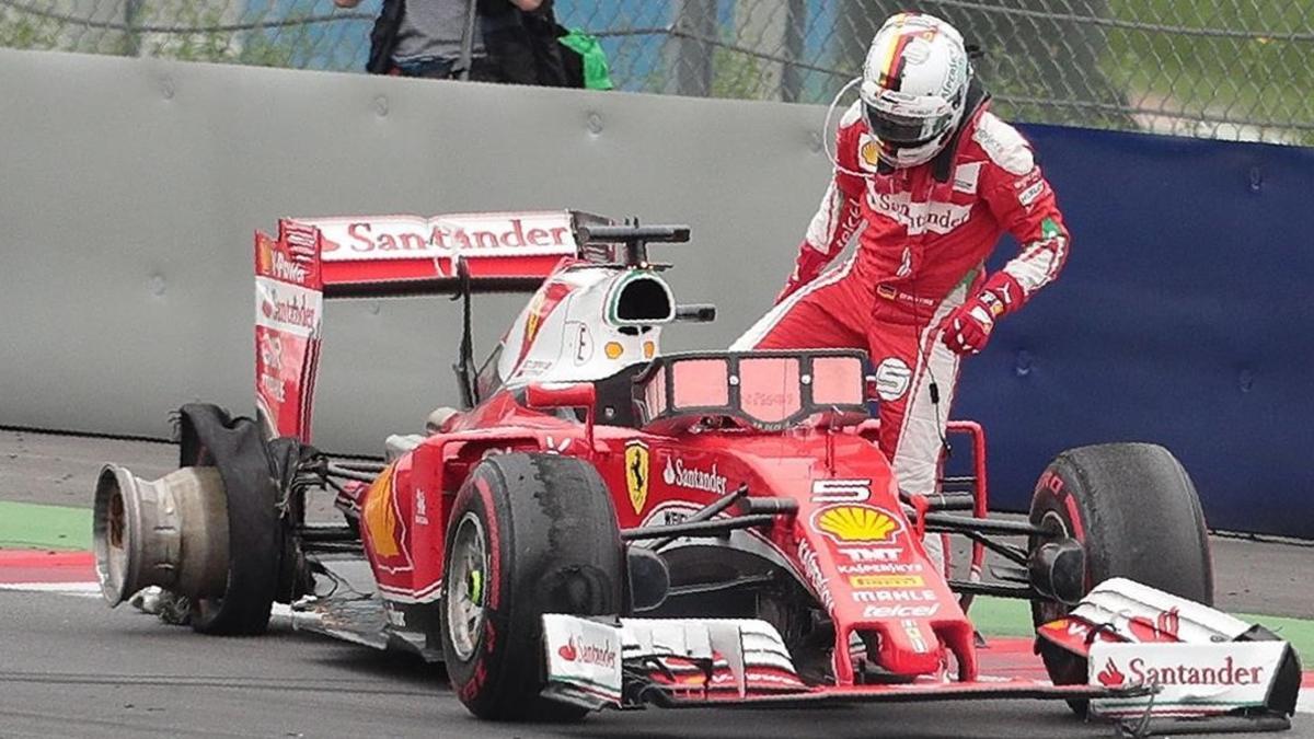 Sebastian Vettel, con su Ferrari y la rueda destrozada.