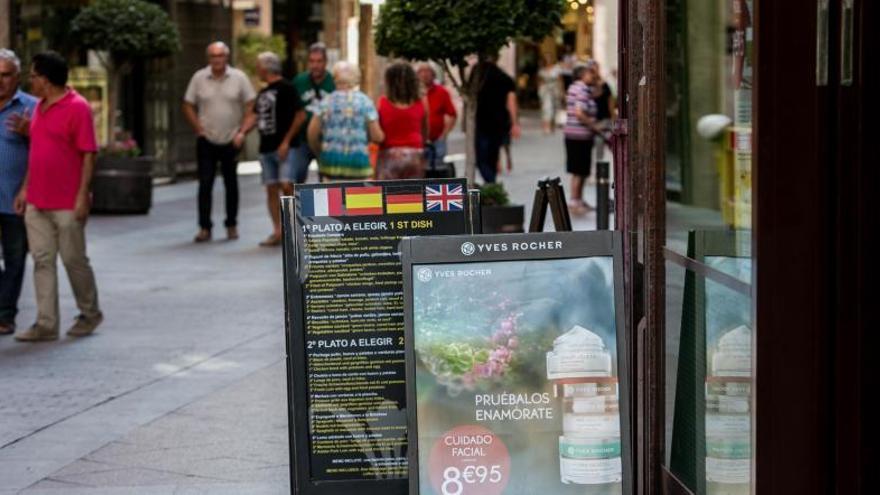 Carteles de un establecimiento comercial instalados en Elche.