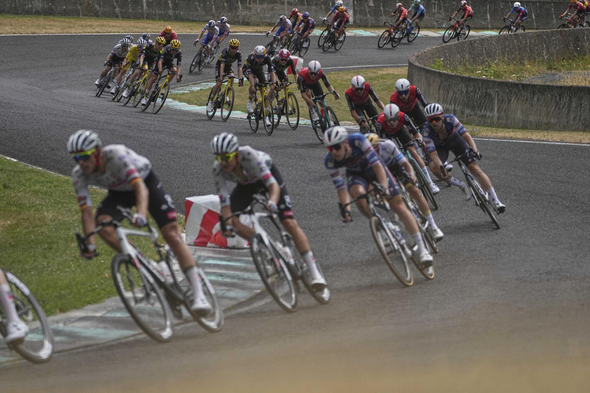 The pack rides on the Charade Circuit during the tenth stage of the Tour de France cycling race over 165.3 kilometers (102.7 miles) with start in Ennezat and finish in Le Mont-Dore Puy de Sancy, France, Monday, July 14, 2025. (AP Photo/Thibault Camus). EDITORIAL USE ONLY / ONLY ITALY AND SPAIN