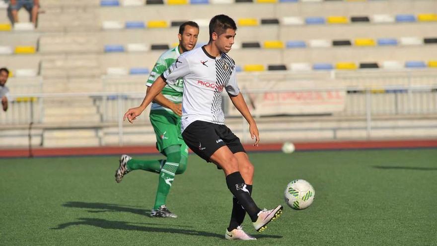 Roni golpea el balón en presencia de Álvaro Muñiz, del Lealtad.