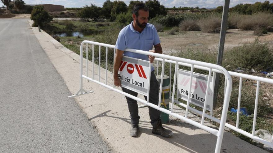 Un operario municipal instalando esta mañana vallas en una zona crítica para cortar el tráfico si se producen inundaciones