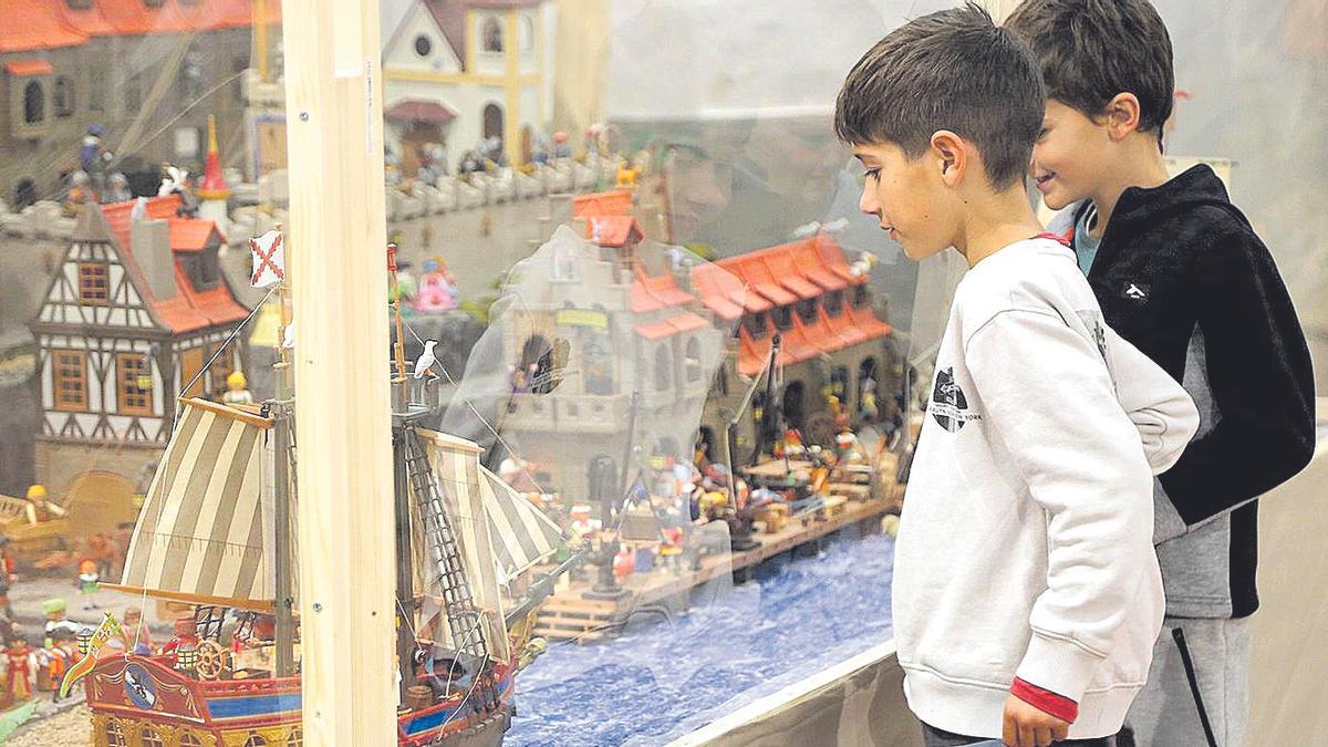 Dos niños contemplan uno de los dioramas expuestos en el salón San Juan de Dios.