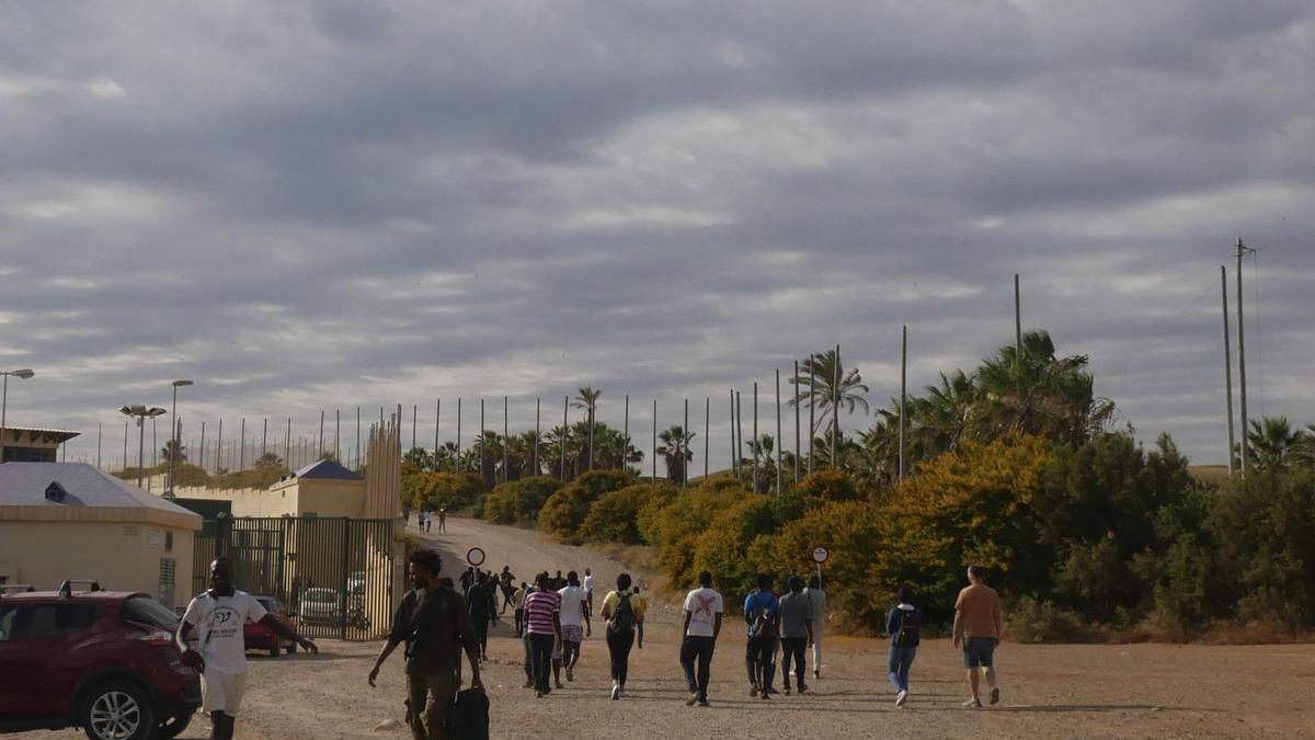 Varias decenas de inmigrantes se dirigen al Centro de Estancia Temporal de inmigrantes (CETI) tras entrar este viernes en Melilla tras romper la puerta de acceso al paso fronterizo de Barrio Chino.