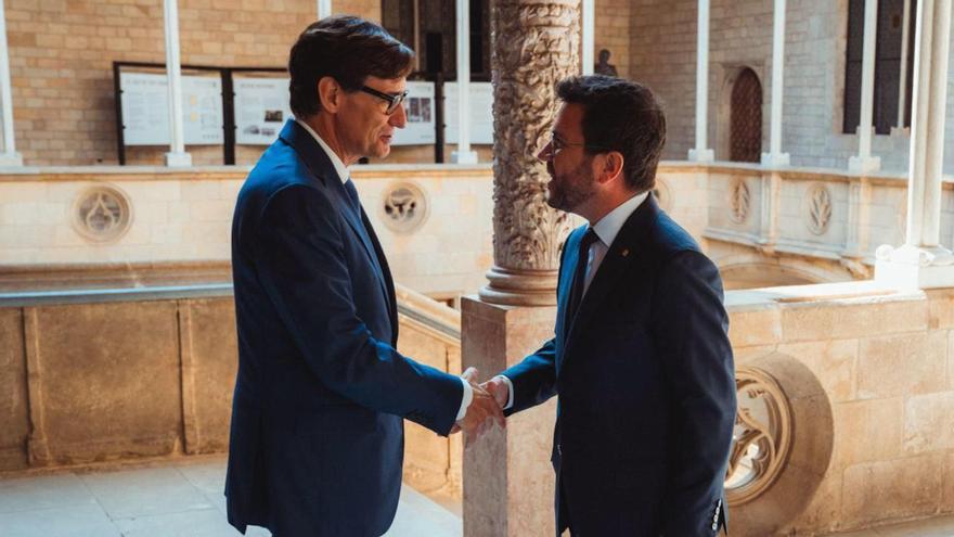 El presidente de la Generalitat electo, Salvador Illa, encaja manos con el presidente saliente, Pere Aragonès.