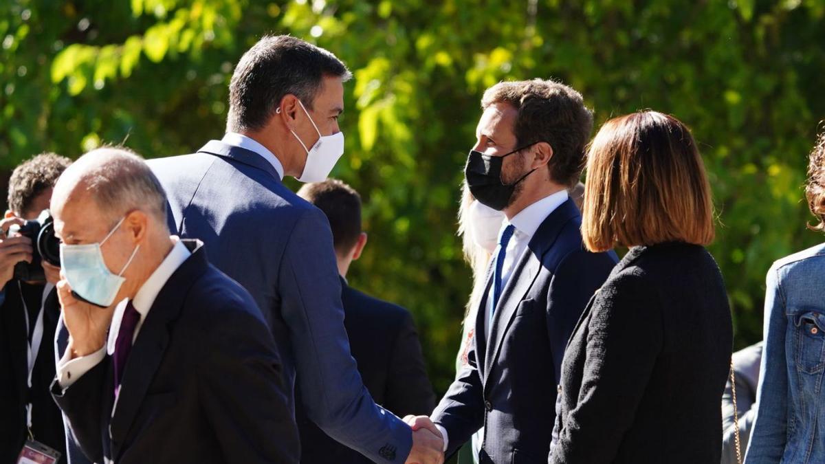 Pedro Sánchez i Pablo Casado se saluden en un acte a l’octubre. | EUROPA PRESS
