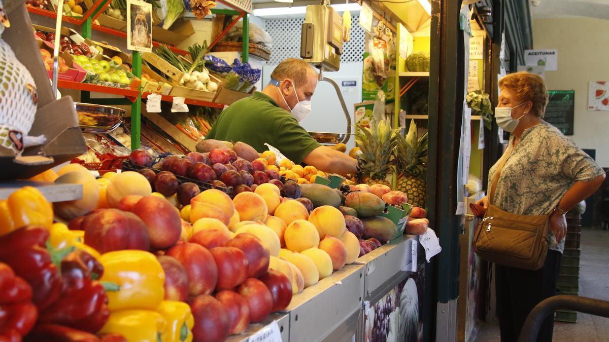 Una mujer comprando en el mercado de La Corredera.