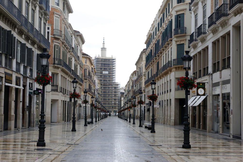 Pasan los días de confinamiento y la situación de la ciudad sigue siendo desértica. La siempre frecuentada calle Larios, la Alameda, principal vía de tráfico tanto privado como público del centro de la ciudad, y el bullicioso mercado de Atarazanas presentan durante el estado de alarma provocado por la pandemia de coronavirus una imagen inusual, acentuada por la persistente lluvia de esta semana.