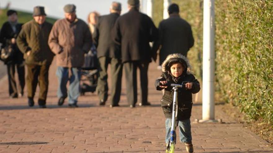 Un niño, abrigado, un día invernal soleado en A Coruña.