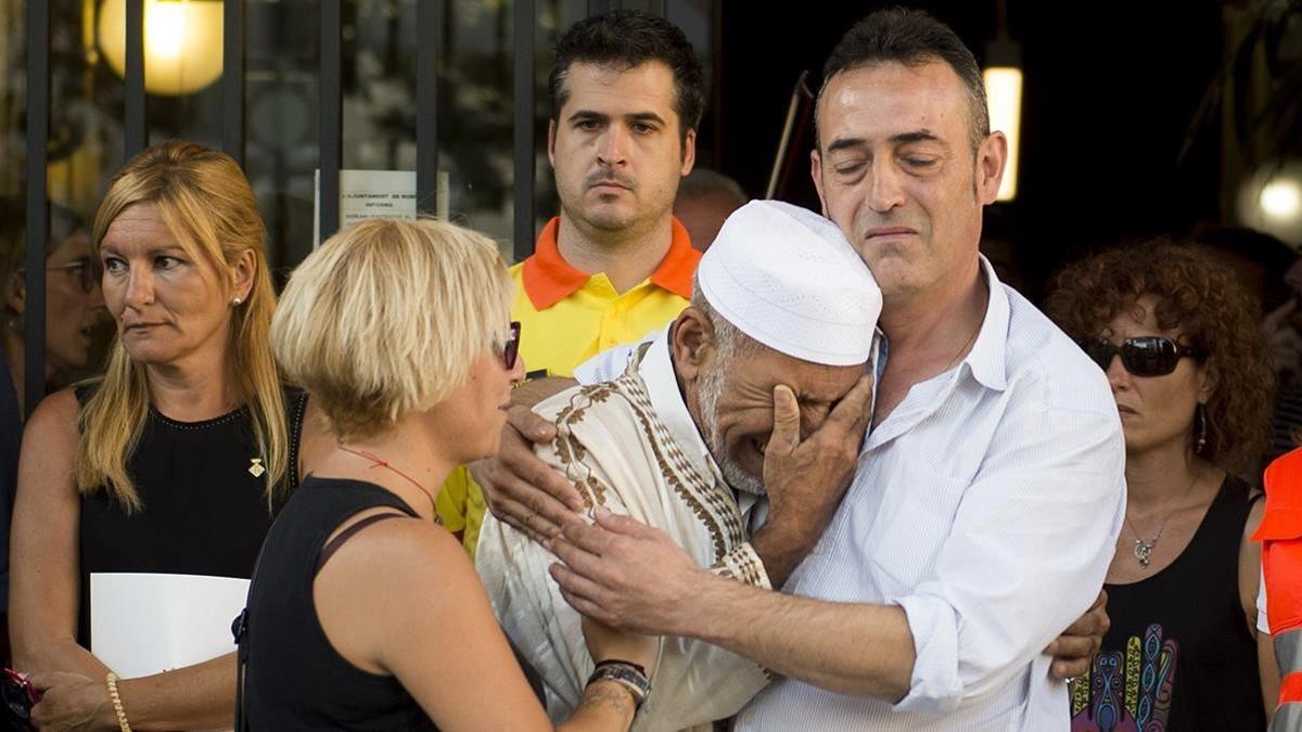 Javier Martinez, padre de Xavi, y Silvia, la madre de la victima de tres años de los atentados, emocionados junto al imán Driss Sallym en un acto organizado en Rubí