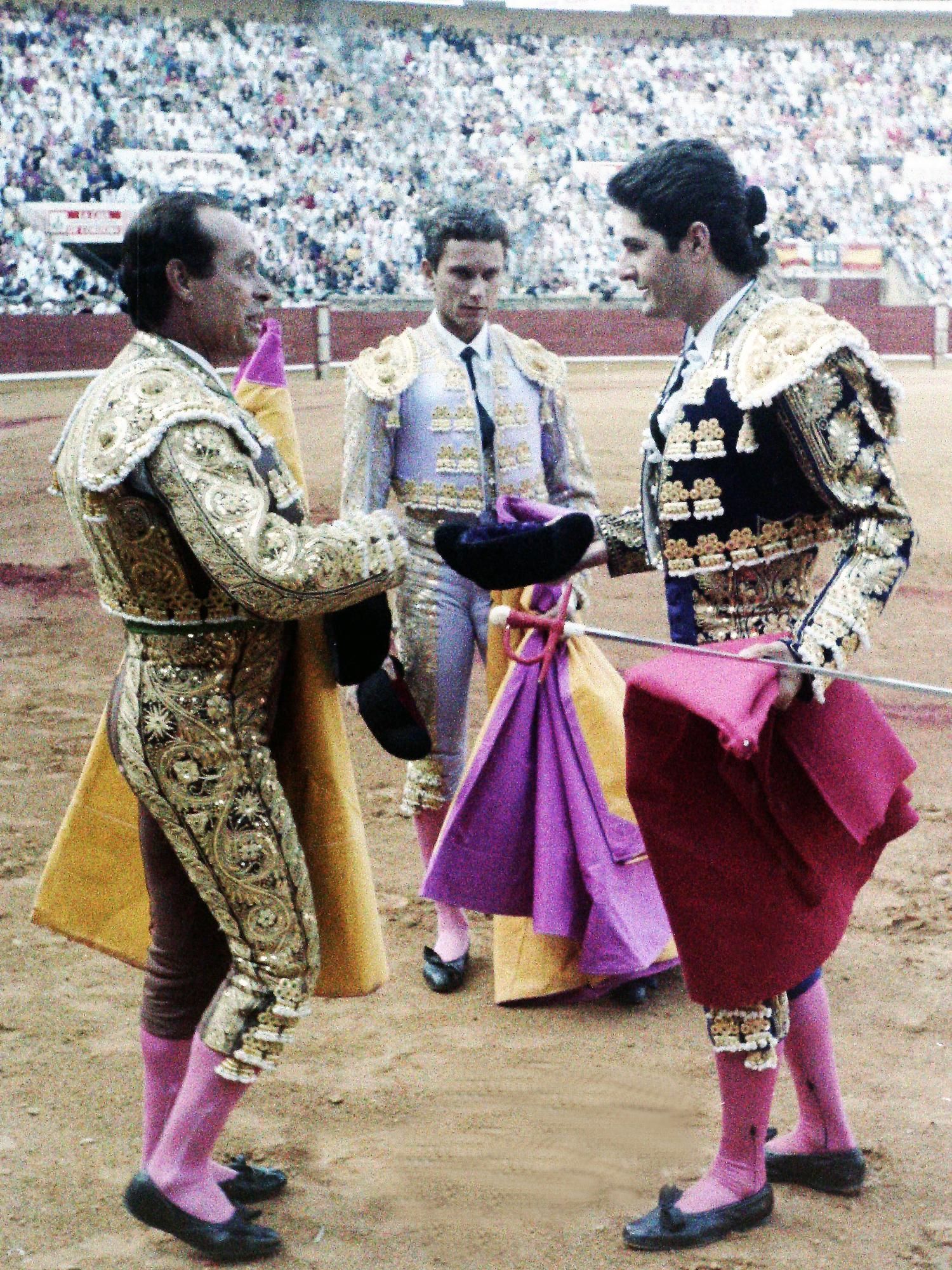 Momento en el que Curro Romero da la alternativa a Chiquilín con Julio Aparicio como testigo.