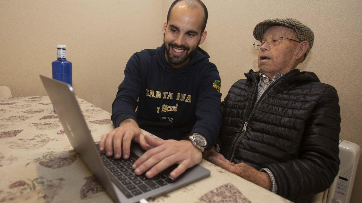 Daniel Rodes y su abuelo frente al ordenador haciendo trámites. / PILAR CORTÉS