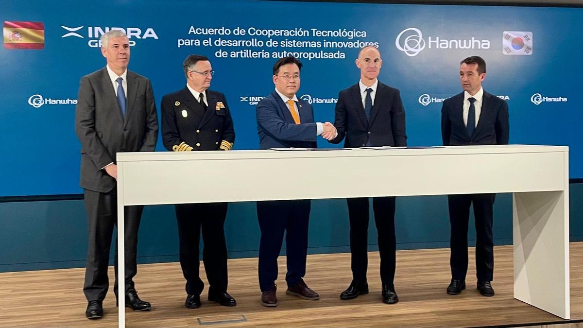 Firma este martes del acuerdo entre Indra y la coreana Hanwha para producir una variante española del obús autopropulsado K9. De izquierda a derecha, José Vicente de los Mozos, CEO de Indra, el almirante Aniceto Rosique, director general de Armamento y Material de Defensa, el  ejecutivo coreano Maro Kim, su homólogo en Indra Fran Torres y el presidente de la compañía española, Ángel Escribano