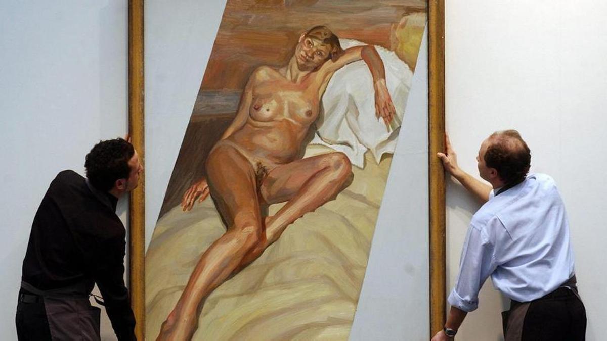 Dos trabajadores transportan el lienzo que Freud pintó de Kate Moss embarazada.  