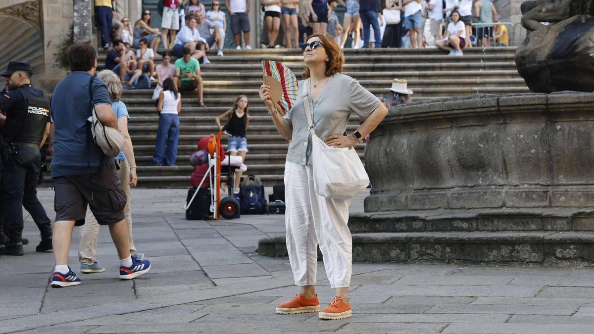 Una mujer se abanica por el calor en la praza das Praterías, en Santiago