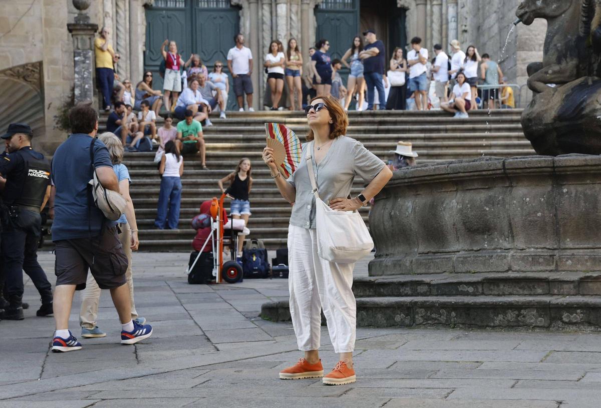 Una mujer se abanica por el calor este martes en la praza das Praterías, en Santiago