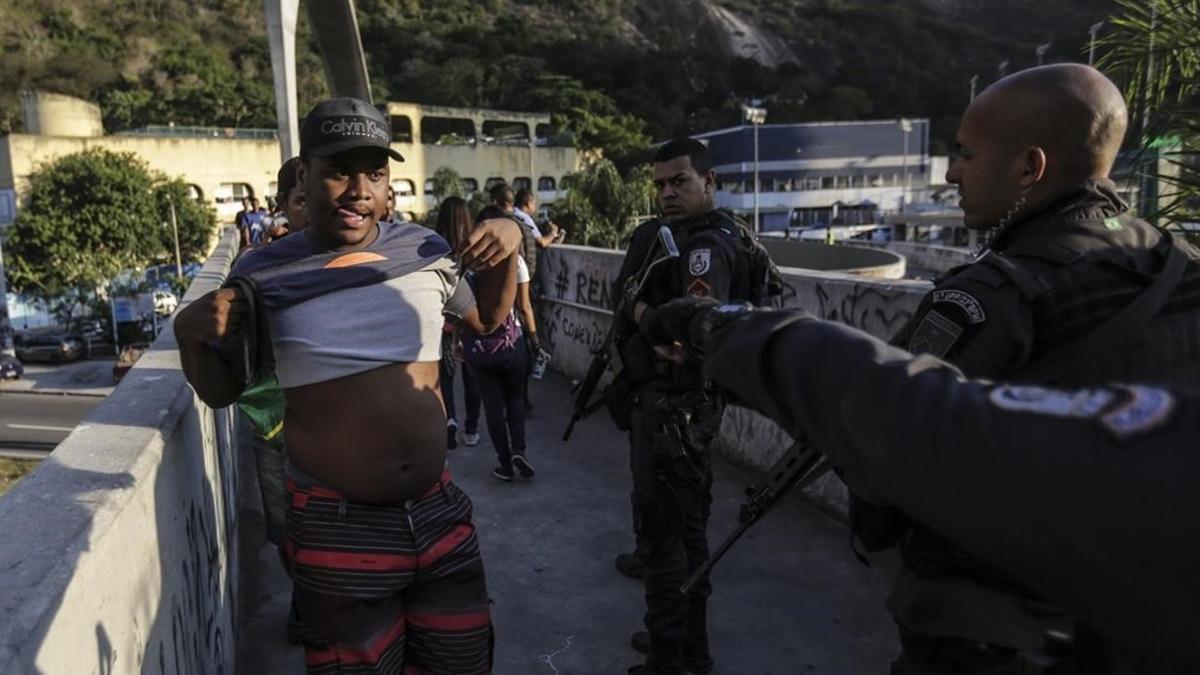 Agentes de la policia patrullan frente a la favela Rocinha durante una marcha de los habitantes pidiendo paz, el jueves 19 de octubre de 2017 , en Río de Janeiro, Brasil.