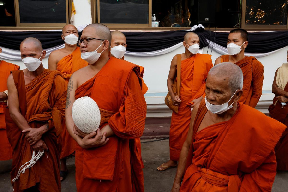 La gente observa cómo las piras funerarias incineran a 19 víctimas del tiroteo en la guardería de Uthai Suwan en el templo Wat Rat Samakee en Uthai Sawan. Un exoficial de policía disparó y mató a 37 personas, al menos 24 de ellos niños, después de irrumpir en una guardería infantil en el noreste de Tailandia.