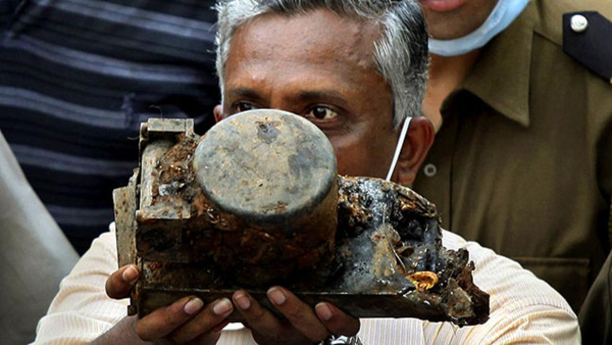 Un oficial d’aviació mostra la que pot ser la caixa negra del Boeing 737 que es va estavellar al sud de l’Índia, en el qual van morir 158 persones.