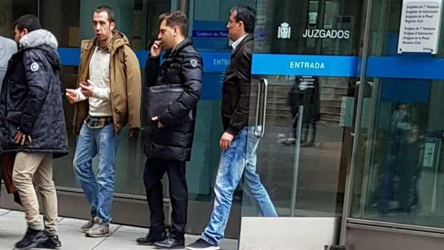 Tres de los acusados, con su abogado, segundo por la derecha, saliendo ayer de los Juzgados.