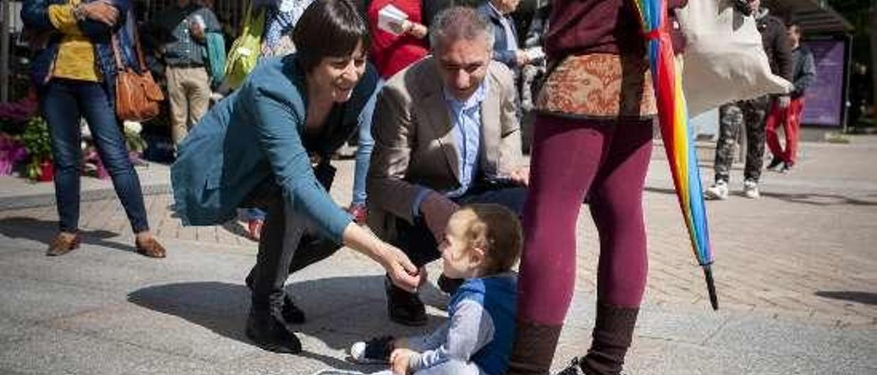 Ana Pontón y Luis Seara saludan a un niño en la praza.// B. Lorenzo