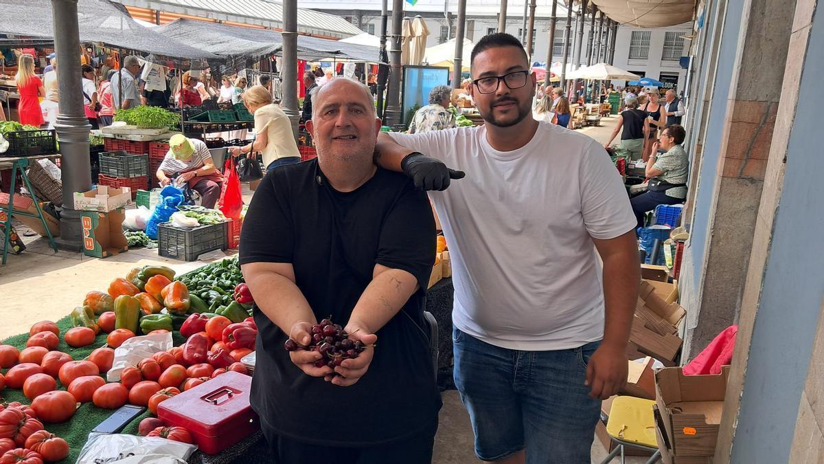 Ramón Gabarri sostiene un puñado de cerezas junto a su hijo Andrés.