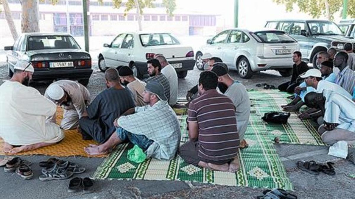 Unos musulmanes rezan en los Camps Elisis, ayer, tras el cierre de la mezquita de la calle del Nord.