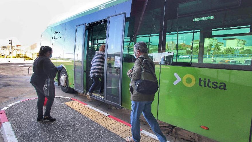 Pasajeros suben a una guagua de Titsa.