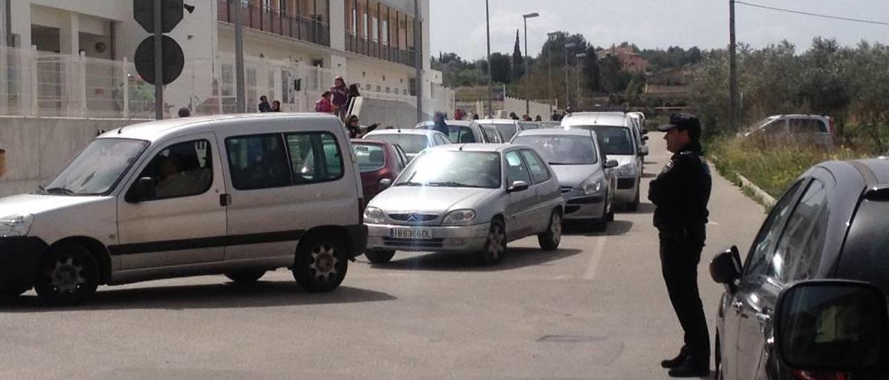 Un policía vigila la salida de alumnos del colegio, ayer.