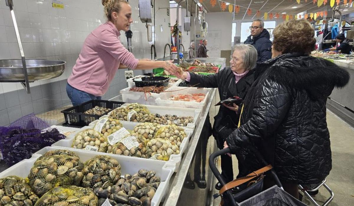 Una mujer abona sus compras en la plaza, ayer. |  M. Méndez