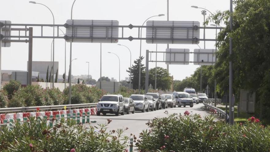 Cola de coches en el acceso al aeropuerto para no consumir minutos gratis del parking exprés.