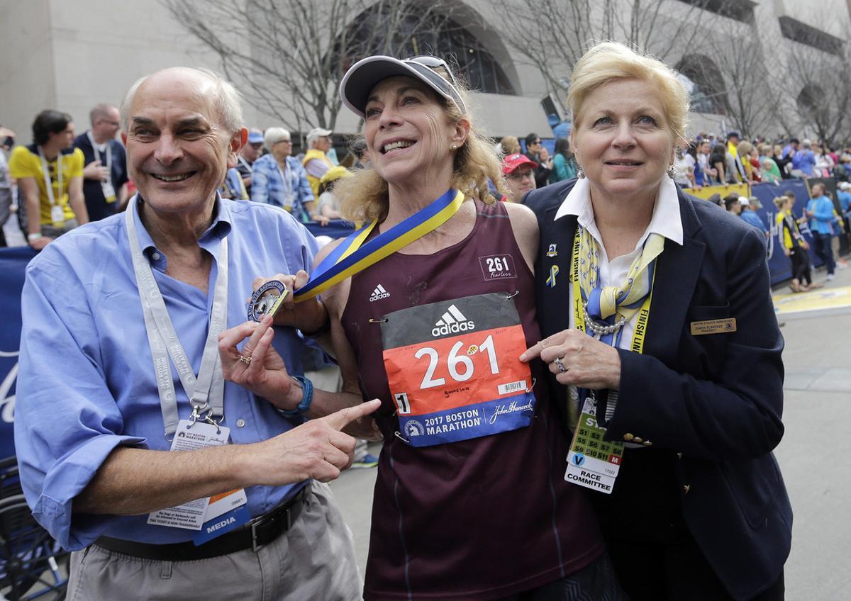 Kathrine Switzer, center, the first official woman entrant in the Boston Marathon 50 years ago, wears the same bib number after finishing the marathon on Monday, April 17, 2017, in Boston. With Switzer are her husband Roger Robinson, left, and Joann Flaminio, right, of the Boston Athletic Association. (AP Photo/Elise Amendola)