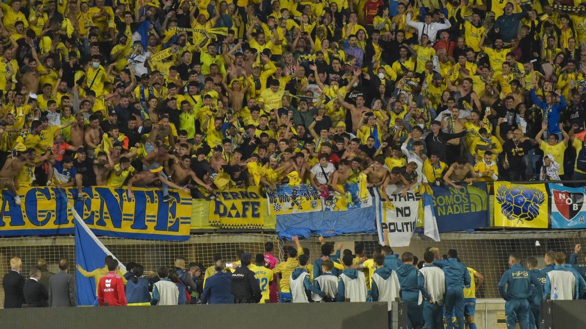 Jugadores y empleados de la UD Las Palmas celebran el triunfo al final del partido con la afición de la grada Naciente.