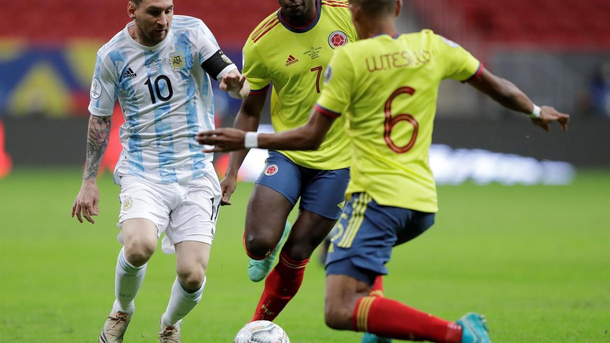 Messi conduce el balón ante dos jugadores de Colombia.