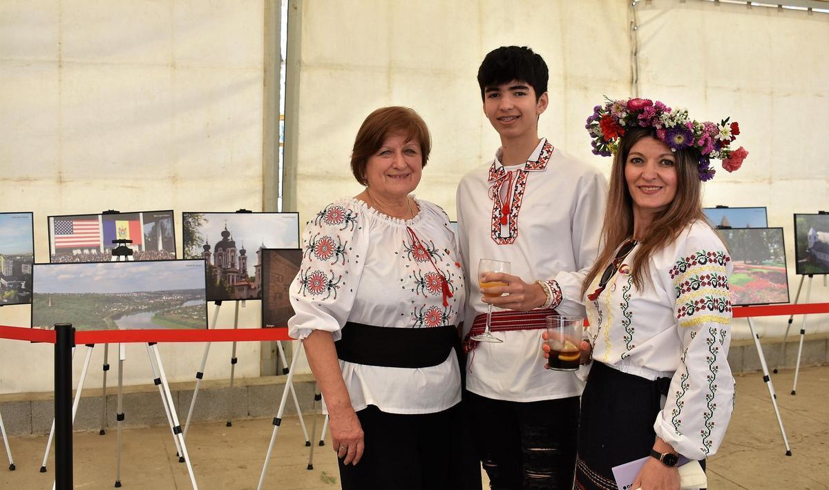 Residentes moldavos con los trajes típicos junto a la exposición de fotografías de Moldavia en la Fiesta del Martisor