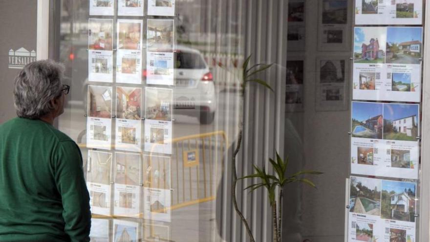 Carteles de alquiler y venta de viviendas en una inmobiliaria de A Coruña.