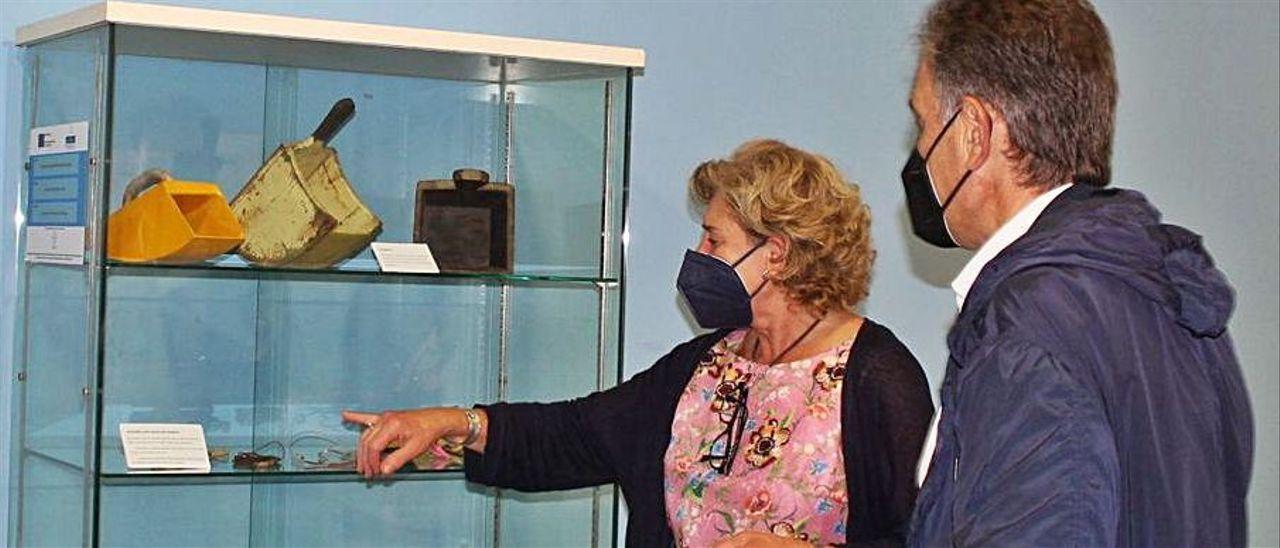 Pilar Carrasco, del Museo Marítimo y el alcalde de Gozón, Jorge Suárez, ayer en la inauguración. Al lado, uno de los artilugios de la exposición