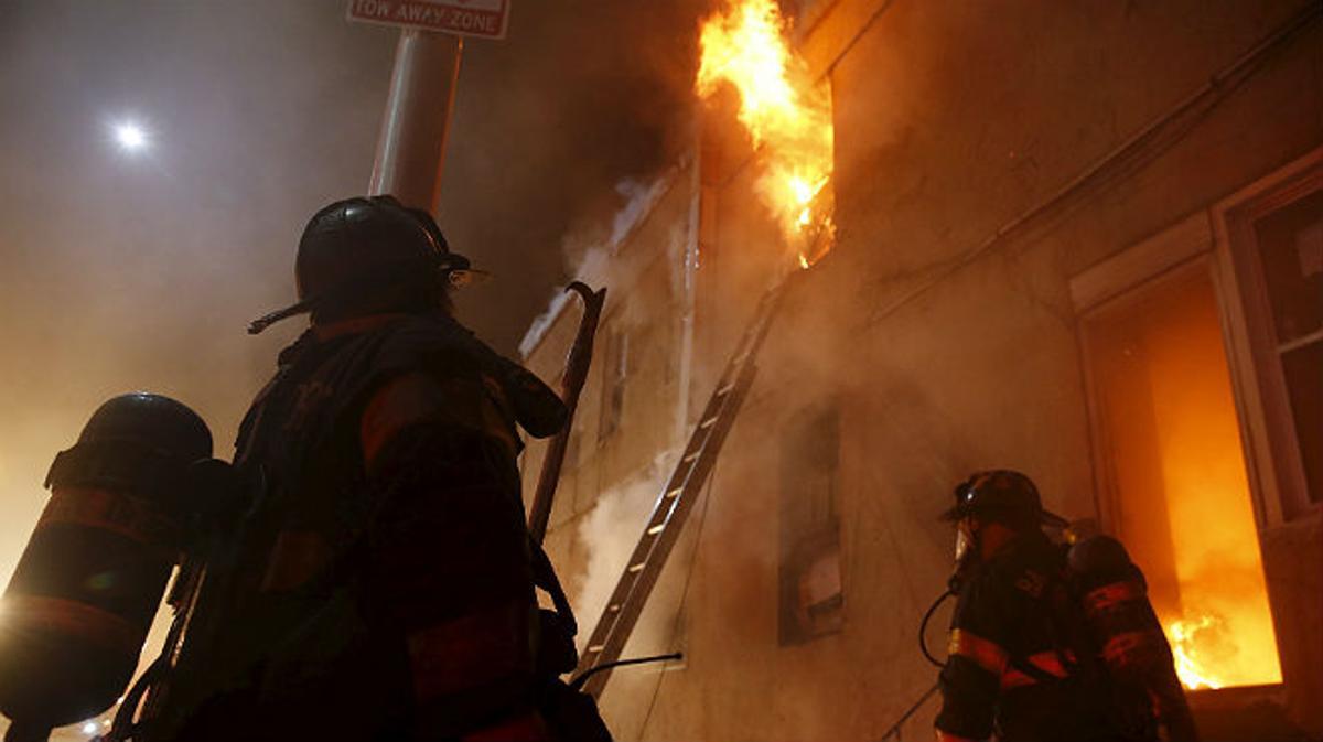 Els bombers treballen per apagar l’incendi provocat en un comerç de Baltimore.