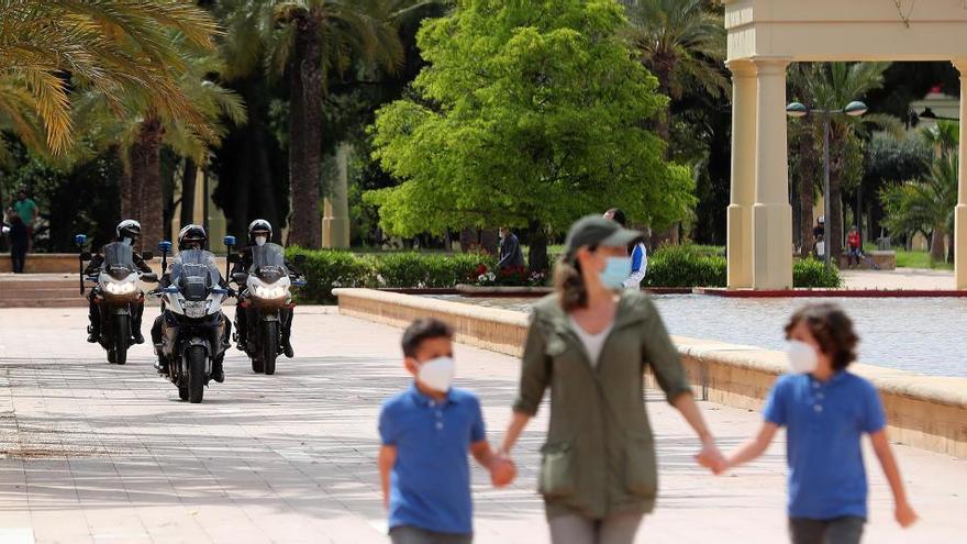 Una mujer pasea con dos niños por Valencia.