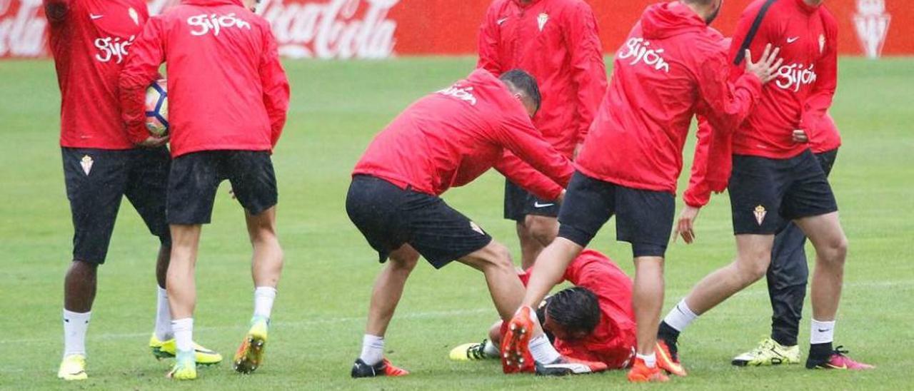 Los jugadores del Sporting bromean durante una fase del entrenamiento de ayer.