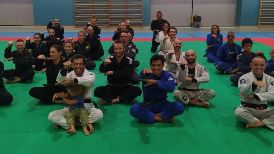 Foto de grupo de los participantes en la actividad haciendo con los brazos el característico gesto de la ‘cobrinha’. 