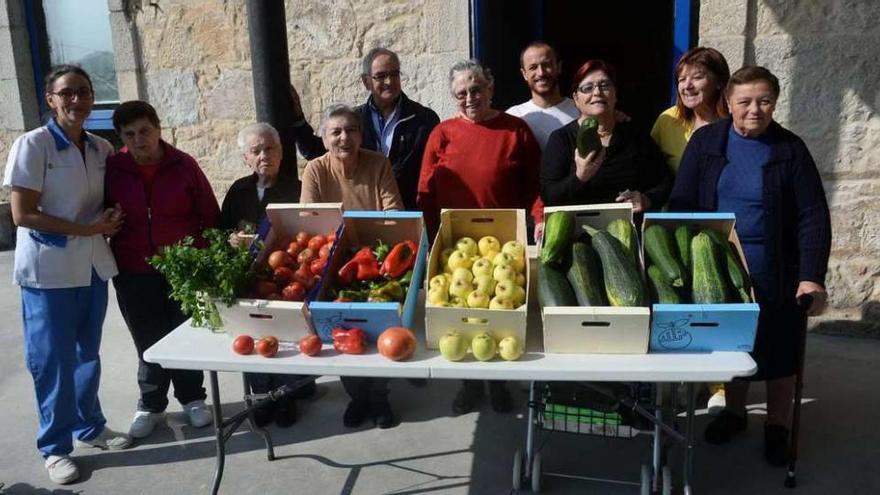 Usuarios del Centro de Día de Portas, de la red de centros públicos del Consorcio Galego de Servizos de Igualdade e Benestar, entregaron ayer la producción al director de Cáritas de A Estrada. // Noé Parga